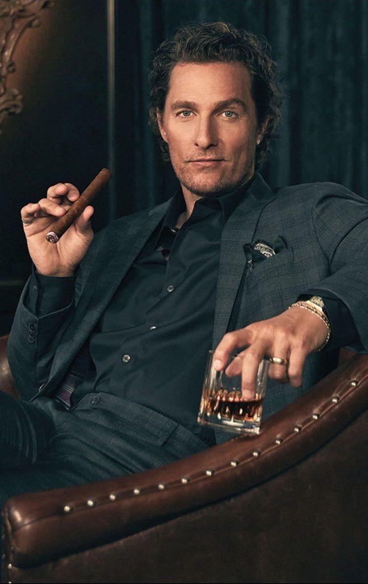 Luxurious life. A successful gentleman in an expensive suit with a cigar and a glass of whiskey or a cup of coffee is eye-catching